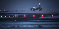 Ein Flugzeug steht auf dem Flughafen in Frankfurt am Main auf dem Rollfeld. Im Vordergrund liegt Schnee.