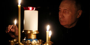 Der russische Präsident Wladimir Putin zündet eine Kerze an