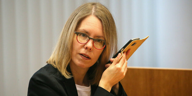Die Oberstaatsanwältin Anne Brorhilker mit einem Smartphone am Ohr