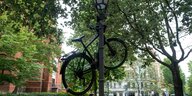 Ein Fahrrad hängt in der Stadt an einer Laterne