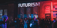 Festivalbesucher vor einer Wand, auf die "Futurism" projiziert ist