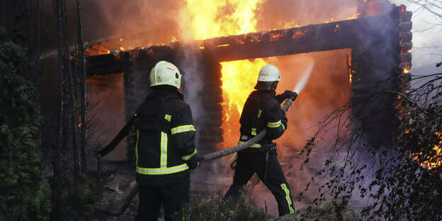 Feuerwehrmänner löschen ein Feuer in einem Haus